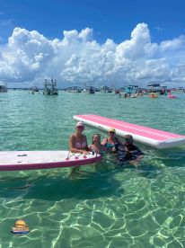 A joyful group enjoys a fun day in clear waters, paddleboarding and swimming together — perfect for family outings and water adventures.