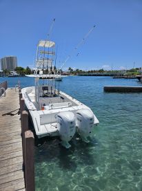 A well-equipped fishing boat is docked, showcasing its twin Yamaha engines and fishing gear, perfect for a day out on the water.