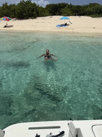 A joyful swimmer enjoys the crystal-clear waters at a beautiful beach, perfect for relaxation and fun in the sun.