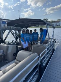 A cheerful group poses on a pontoon boat, ready for a fun day on the water — perfect for celebrations and gatherings with friends.
