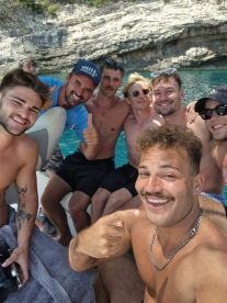 A lively group of friends enjoys a fun day on the water, capturing memories aboard a boat with smiles and camaraderie.