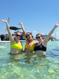 Three friends celebrate in the clear waters, enjoying a fun day out together — perfect for summer adventures and memorable moments on the water.