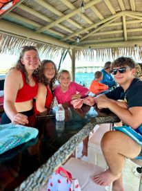 A cheerful group of family members enjoys their time together on a boat, capturing the essence of fun and bonding in a vibrant setting.