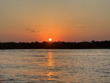 A serene sunset over calm waters, creating a picturesque backdrop perfect for evening boat rides or relaxation on the water.
