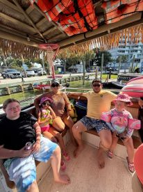 A joyful family enjoys a sunny day aboard a boat, creating lasting memories with kids in life jackets — perfect for family outings on the water.