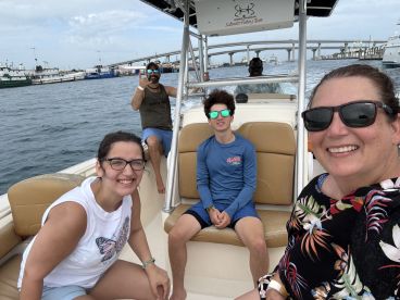 A cheerful family enjoys a boat ride, capturing smiles and fun moments together on the water — perfect for family outings and adventures.