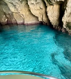 A stunning view of turquoise waters inside a cave, showcasing the natural beauty of the coastline — perfect for eco tours and scenic boat trips.