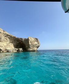 A stunning view of a rocky coastline against crystal-clear turquoise waters, perfect for showcasing the natural beauty of the area.