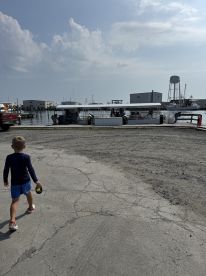 A child walks towards a boat at the dock, creating a charming scene of anticipation for a boating adventure.