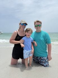 A joyful family enjoys a day at the beach, with children playing in the water — perfect for memorable family outings and summer fun.