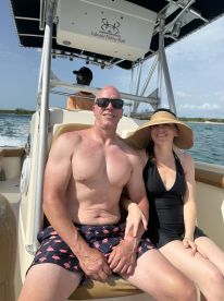 A couple enjoys a sunny day on a fishing boat, capturing a moment of relaxation and fun on the water.