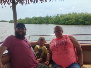 A family enjoys a relaxing moment on a boat surrounded by lush mangroves, perfect for creating lasting memories on the water.