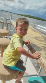 A young boy sits at the bar area of a boat, enjoying the view of the water. This cozy interior space is perfect for family outings on the water.