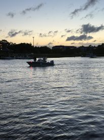 A boat navigates through calm waters at sunset, creating a picturesque scene perfect for evening cruises and relaxation on the water.