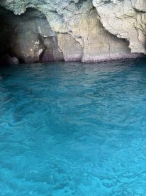 A view of a rocky cave with turquoise water, but the image lacks clarity and focus.