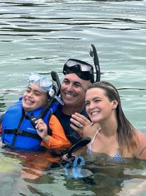 A joyful family enjoys snorkeling together in the water, creating unforgettable memories during their aquatic adventure.