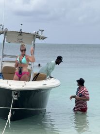 A fun moment captured with friends enjoying a day on the water, showcasing a lively atmosphere with a boat in the background.