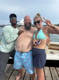 A joyful group poses for a fun photo on a dock, celebrating their time on the water — perfect for capturing memorable moments during a boat trip.