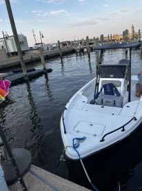 A sleek speedboat docked at the marina, showcasing its design against a serene water backdrop — perfect for a day out on the water.