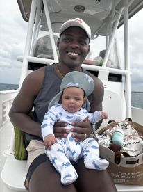 A joyful moment captured on a boat with a father and his baby, showcasing the special bond and fun of family outings on the water.