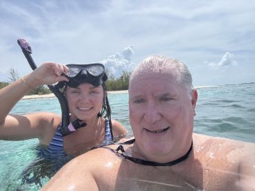 A couple enjoys snorkeling in crystal-clear waters, showcasing the beauty of their aquatic adventure.