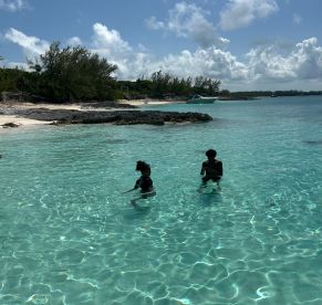 Two children enjoy a refreshing swim in the crystal-clear waters of a beautiful beach, perfect for family adventures and fun in the sun.