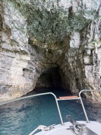 A stunning view of a boat approaching a natural cave, showcasing the beauty of marine exploration and the allure of hidden destinations.