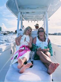 Two friends relax on the deck of a boat, enjoying their time together on the water — a perfect moment for friendship and fun.