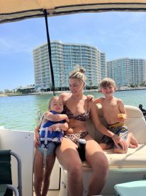 A joyful family enjoys a sunny day on the boat, with kids having fun and creating lasting memories on the water.