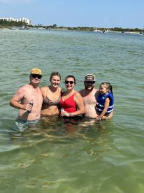 A joyful group enjoys a sunny day swimming in shallow waters, creating lasting memories together — perfect for family outings and beach adventures.