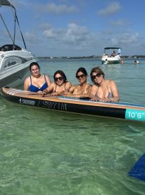 A group of friends enjoys a fun day paddleboarding in clear waters, creating unforgettable memories under the sun.