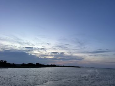 A serene view of the water and sky at dusk, capturing the tranquil ambiance of the evening.