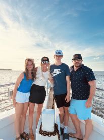 A joyful family poses together on a boat, capturing a memorable moment on the water — perfect for family outings and celebrations.