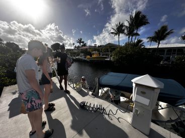 A lively group enjoys a sunny day at the dock, preparing for a boating adventure with drinks in hand. Perfect for fun-filled outings on the water.