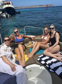A lively group of friends enjoys sunbathing on a boat, creating unforgettable memories on the water. Perfect for a fun day out with friends!