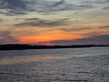 A stunning sunset over tranquil waters, showcasing the beauty of nature and perfect for romantic evening cruises or peaceful reflections.