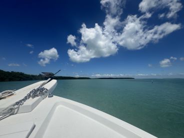A stunning view from the front of a yacht, showcasing the tranquil waters and vibrant blue sky, perfect for a day of relaxation on the water.