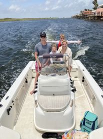 A joyful family enjoys a day on the water, capturing fun moments aboard their boat — perfect for creating lasting memories during summer adventures.
