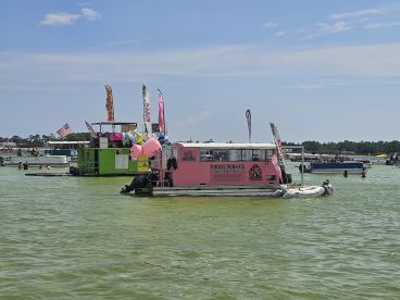 A lively scene at a floating restaurant, Pirate Porky's, with guests enjoying water activities and the vibrant atmosphere — perfect for summer fun on the water.
