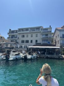 A vibrant waterfront scene featuring boats docked near a popular restaurant, with guests enjoying their time in the sun — perfect for a relaxing day by the water.