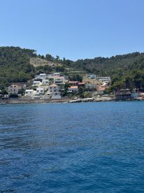 A picturesque view of a coastal village nestled among lush greenery, showcasing the beauty of island life and serene waters.
