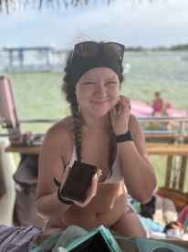 A cheerful woman enjoys her time on a boat, showcasing a fun and relaxed atmosphere on the water. Perfect for capturing memorable moments during a day out at sea.