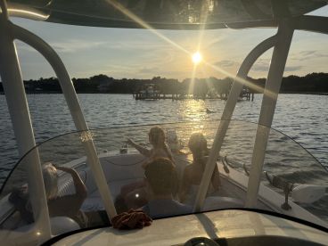 A group enjoys a beautiful sunset from the deck of a boat, creating a perfect backdrop for memorable moments on the water.