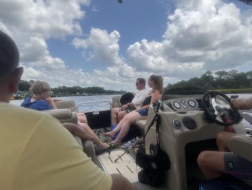 A group enjoys a relaxing day on a pontoon boat, capturing the essence of family fun on the water with beautiful scenery in the background.