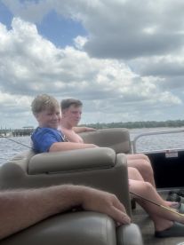 Two boys enjoy a relaxing day on a pontoon boat, capturing the essence of family fun on the water.