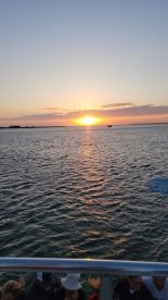A stunning sunset over the water, with guests enjoying the view from the boat — a perfect moment for relaxation and scenic beauty on the water.