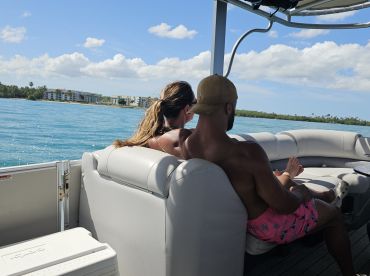 A couple enjoys a relaxing moment on a boat, surrounded by beautiful waterfront scenery — perfect for romantic getaways or leisurely days on the water.