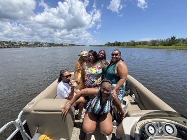 A lively group of friends enjoys a fun day on a pontoon boat, celebrating together on the water. Perfect for memorable outings and gatherings.
