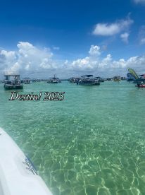 A vibrant scene of boats anchored in the clear waters of Destin, showcasing a lively sandbar stop perfect for summer fun and relaxation.