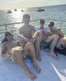 A group of friends relaxes on a boat under the sun, enjoying their time together on the water — perfect for summer outings and celebrations.